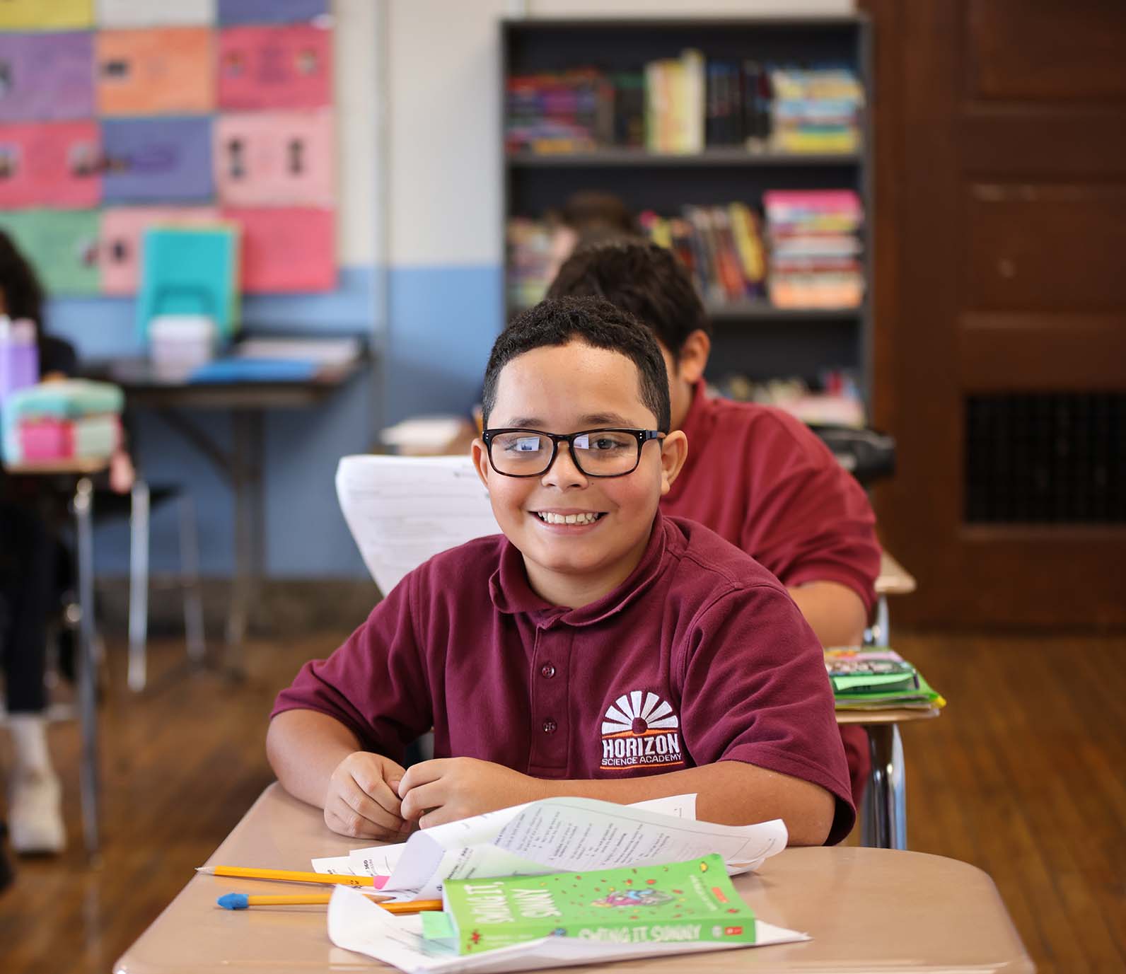 Horizon Science Academy Denison student wearing headphones uses a laptop in class