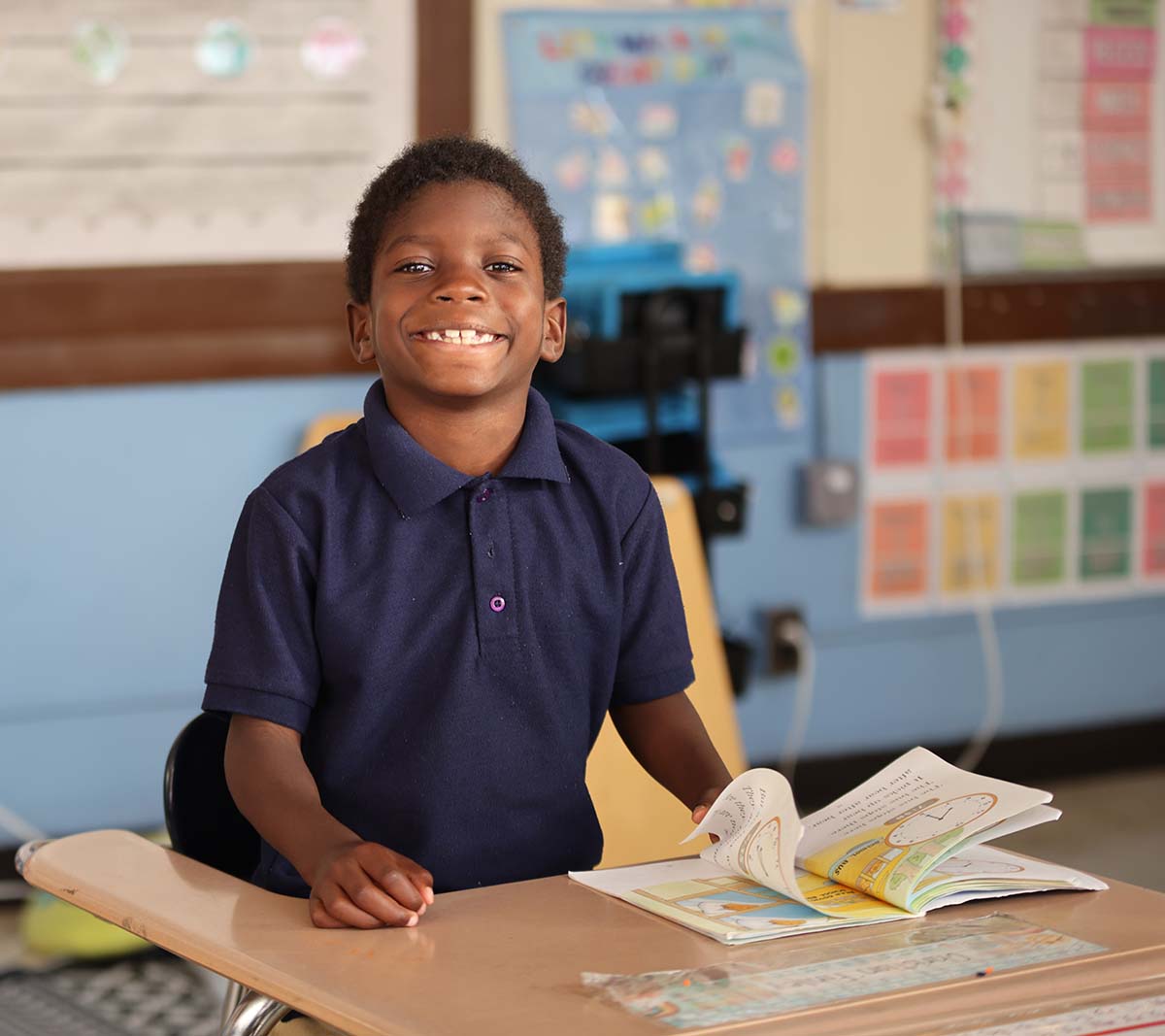 Student working on a notebook in a classroom.